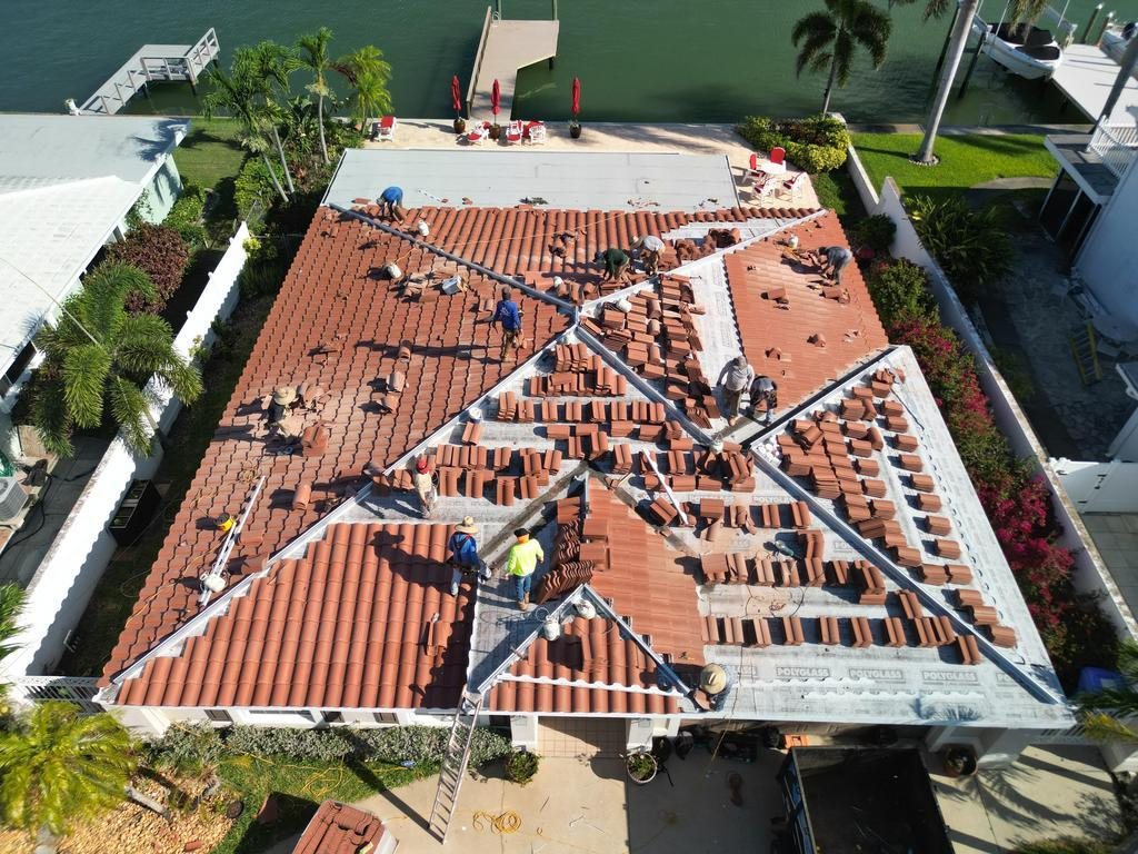 Spangler crew installing a tile roof on a waterfront home, tiles staged across the roof