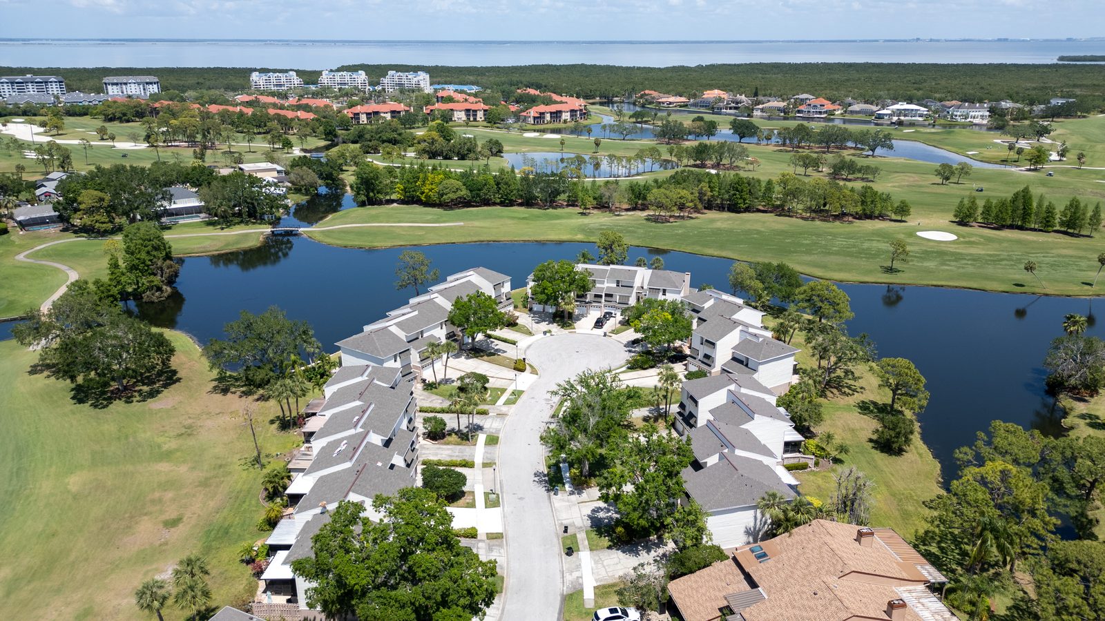Aerial view of a waterfront townhouse community on a golf course